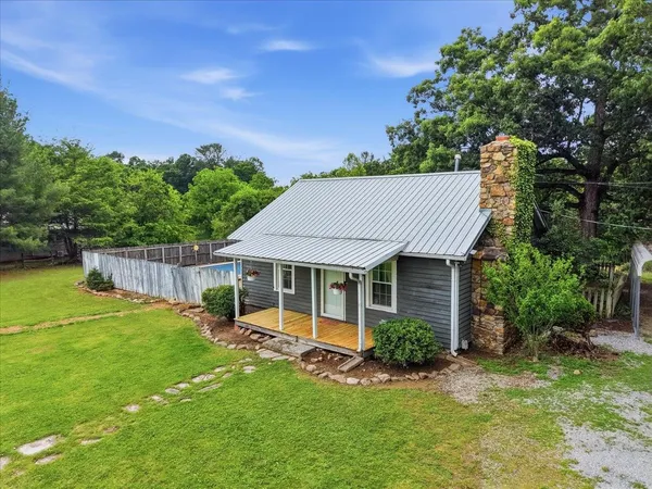 a view of a house with a backyard and a tree