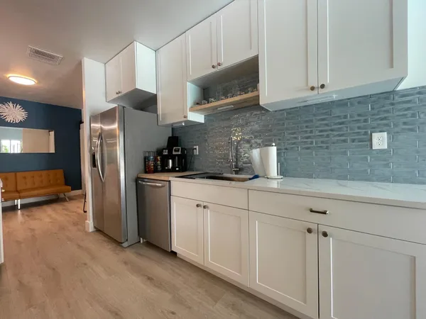 a kitchen with stainless steel appliances granite countertop a refrigerator sink and microwave