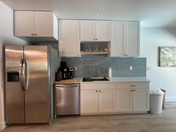 a kitchen with white cabinets and stainless steel appliances