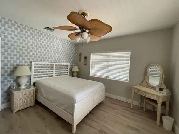 a bedroom with a bed a dresser and chair