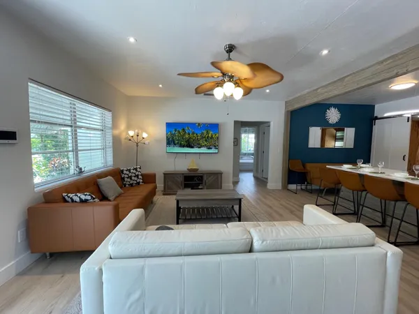 a living room with furniture a flat screen tv and a large window