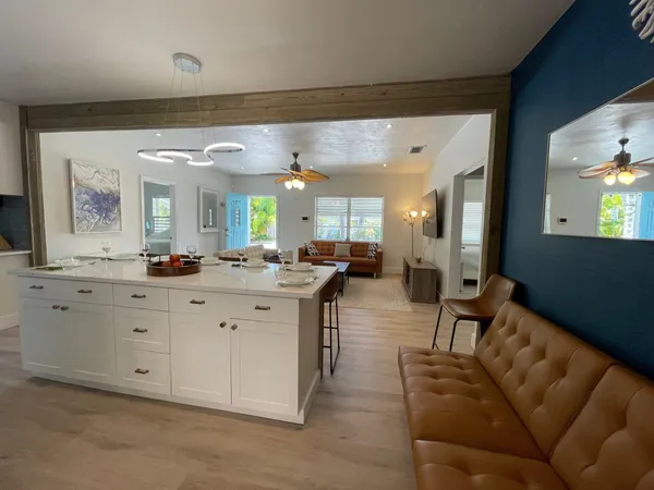 a living room with furniture a large mirror and a view of living room