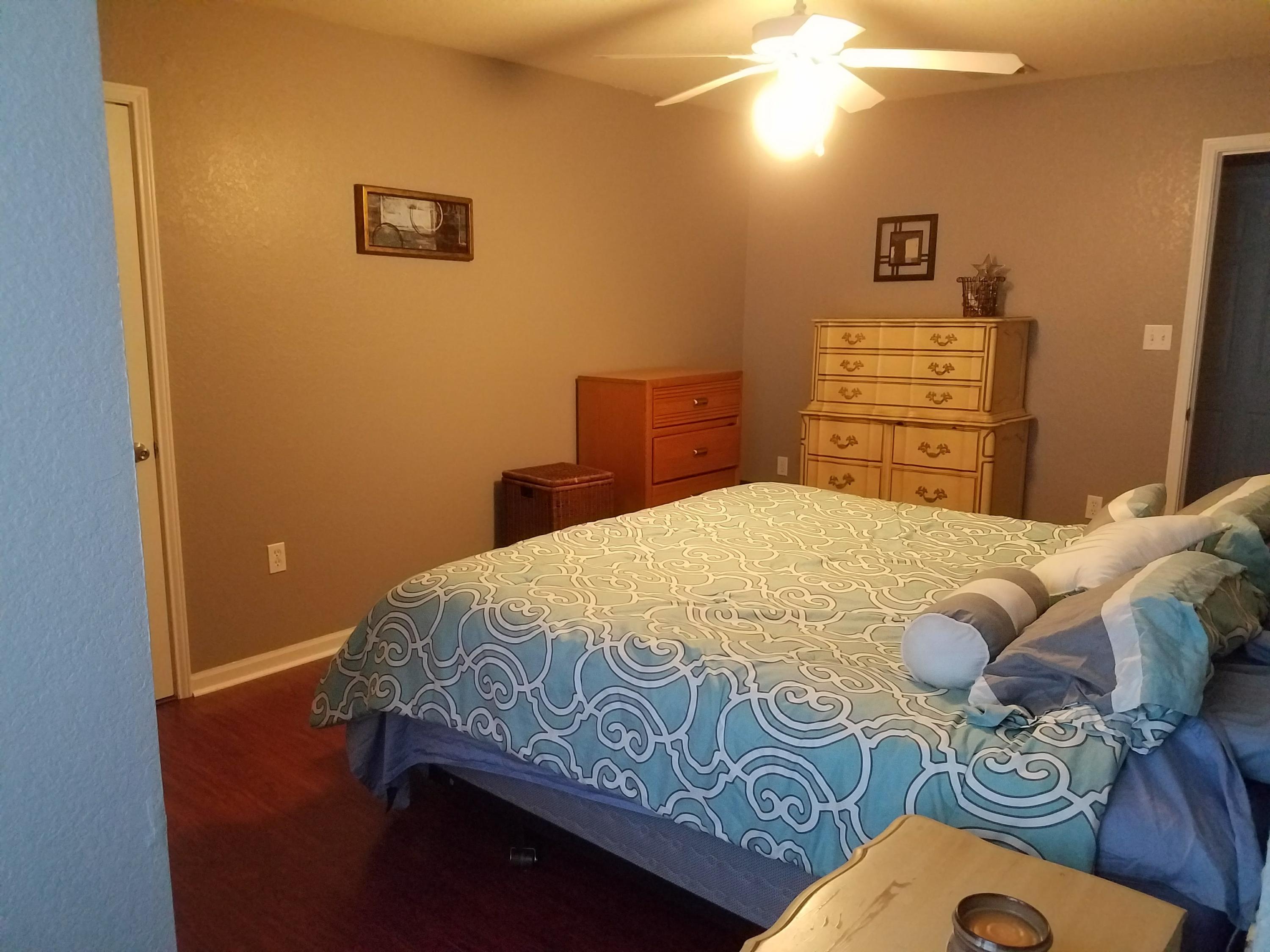 1014 Airport Road, Unit 105 Destin, FL 32541 - Photo 13 of 25 a bedroom with a bed and a lamp on dresser