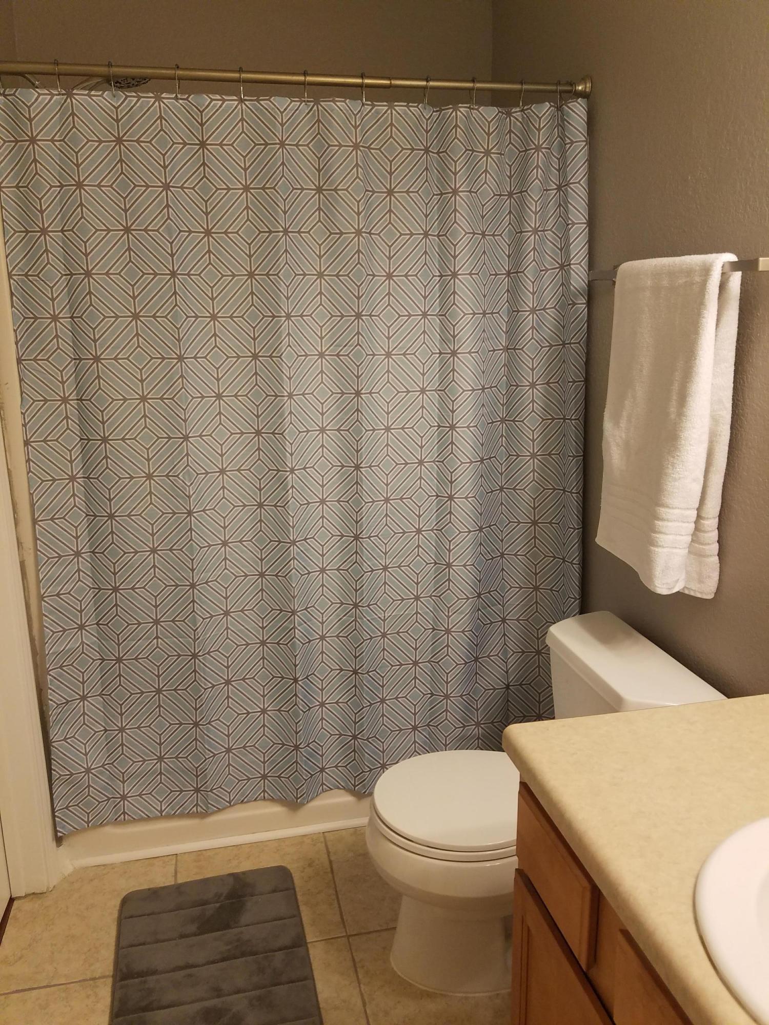 1014 Airport Road, Unit 105 Destin, FL 32541 - Photo 16 of 25 a bathroom with a toilet and a shower curtain