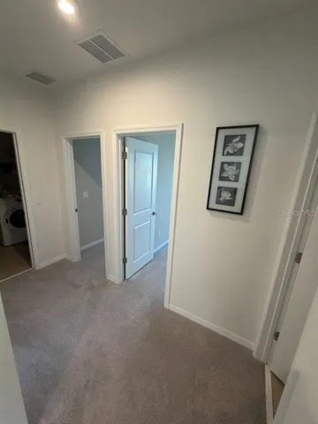 an empty room with painting and refrigerator