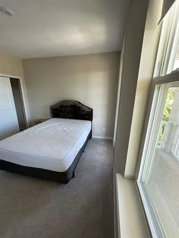 a bedroom with a bed and a large window