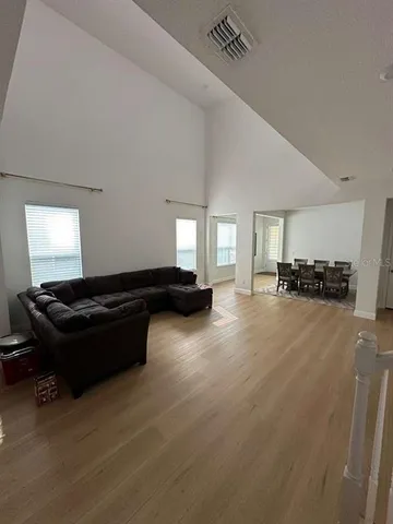 a living room with a black white checkered floor with couches chair and a coffee table