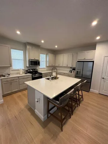 a kitchen with a sink a counter top space stainless steel appliances and cabinets