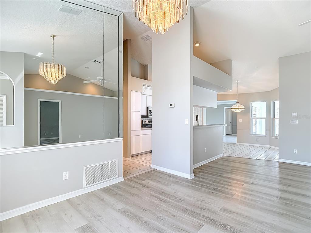 1039 Greenturf Road Spring Hill, FL 34608 - Photo 12 of 60 a view of a hallway with wooden floor and a kitchen