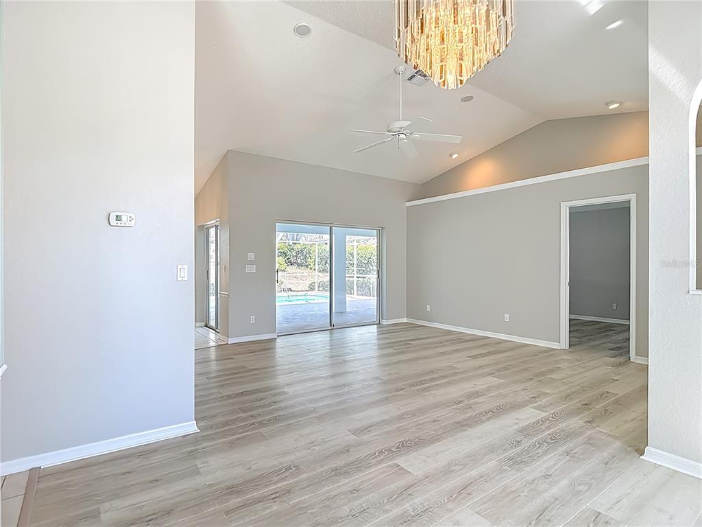 1039 Greenturf Road Spring Hill, FL 34608 - Photo 13 of 60 a view of an empty room with wooden floor and a window