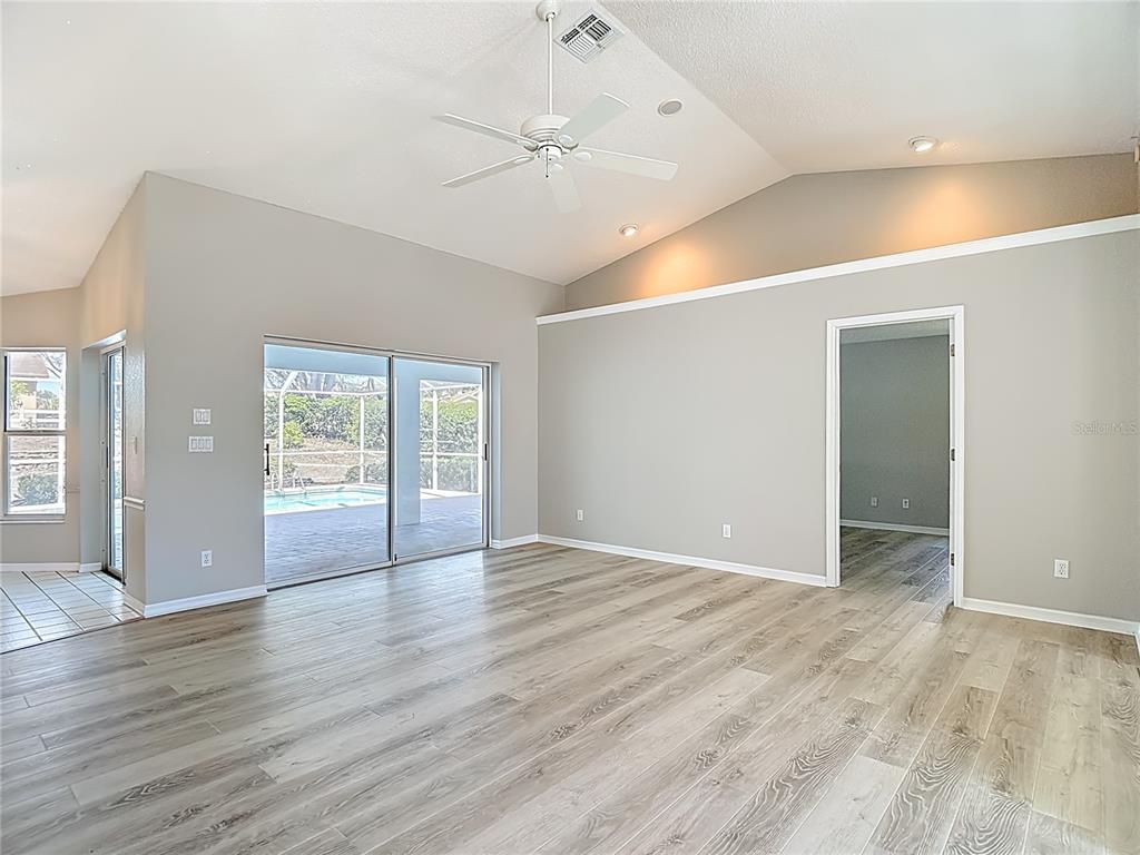 1039 Greenturf Road Spring Hill, FL 34608 - Photo 14 of 60 wooden floor in an empty room with a window