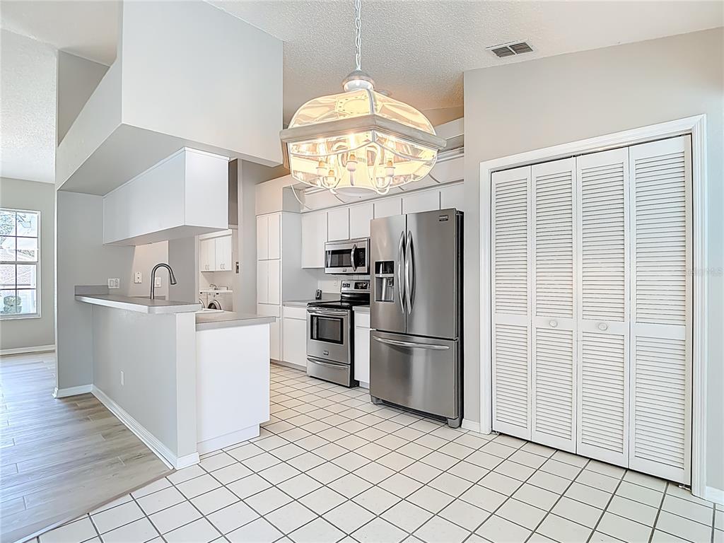 1039 Greenturf Road Spring Hill, FL 34608 - Photo 18 of 60 a kitchen with cabinets and stainless steel appliances
