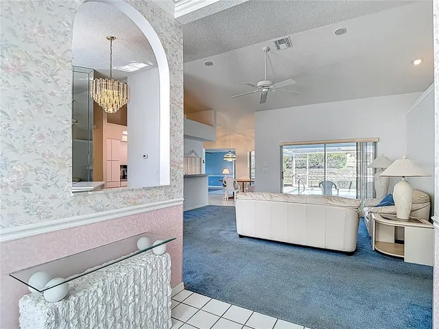 a living room with a large window and a chandelier