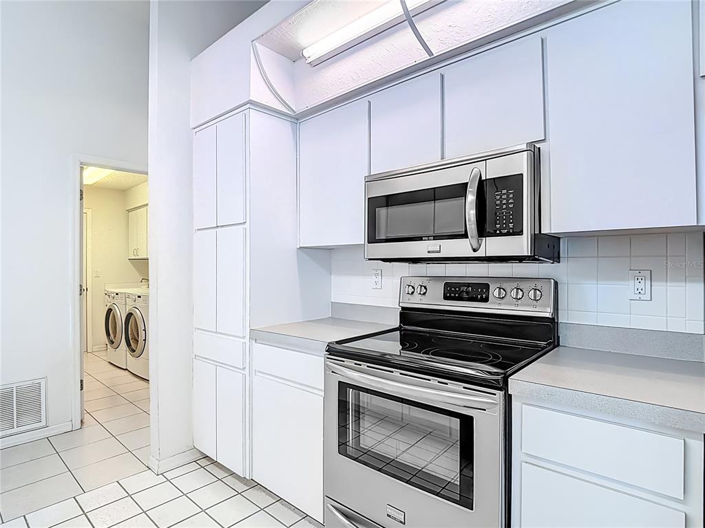 1039 Greenturf Road Spring Hill, FL 34608 - Photo 20 of 52 a kitchen with stainless steel appliances a stove a microwave and cabinets