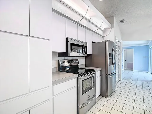 a kitchen with stainless steel appliances a refrigerator sink and microwave