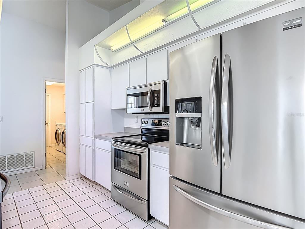 1039 Greenturf Road Spring Hill, FL 34608 - Photo 22 of 52 a kitchen with stainless steel appliances a refrigerator sink and microwave