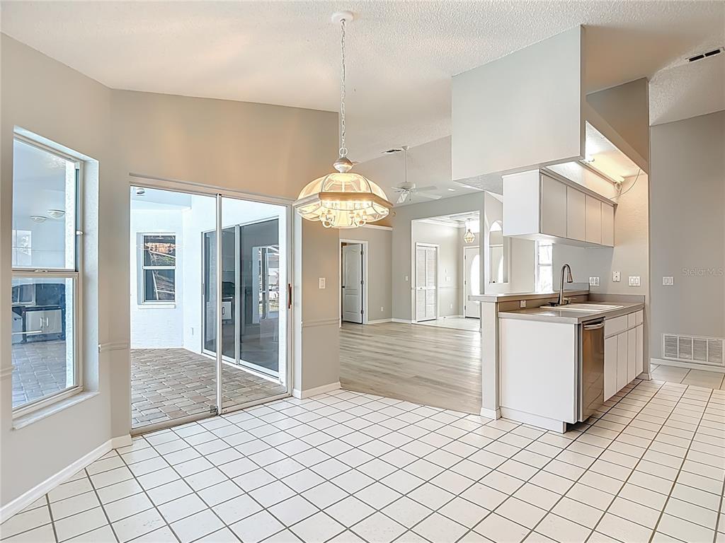 1039 Greenturf Road Spring Hill, FL 34608 - Photo 22 of 60 a large white kitchen with granite countertop a sink and white cabinets