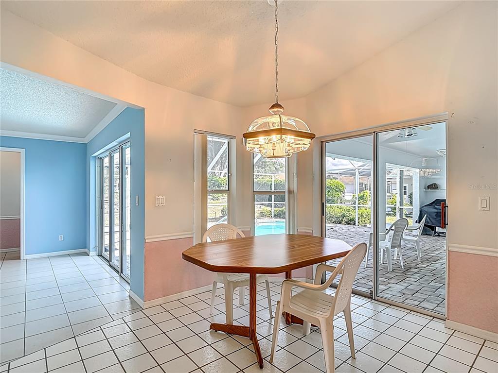 1039 Greenturf Road Spring Hill, FL 34608 - Photo 24 of 52 a view of a dining room with furniture wooden floor and chandelier