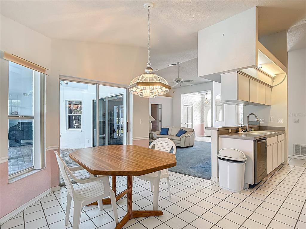 1039 Greenturf Road Spring Hill, FL 34608 - Photo 26 of 52 a kitchen with sink dining table and chairs
