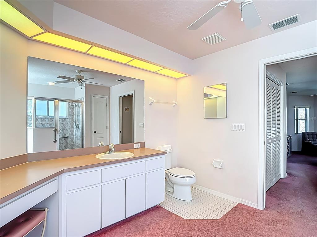 1039 Greenturf Road Spring Hill, FL 34608 - Photo 32 of 52 a spacious bathroom with a granite countertop sink and a mirror