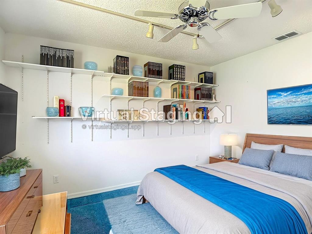 1039 Greenturf Road Spring Hill, FL 34608 - Photo 35 of 52 a bedroom with furniture and a chandelier