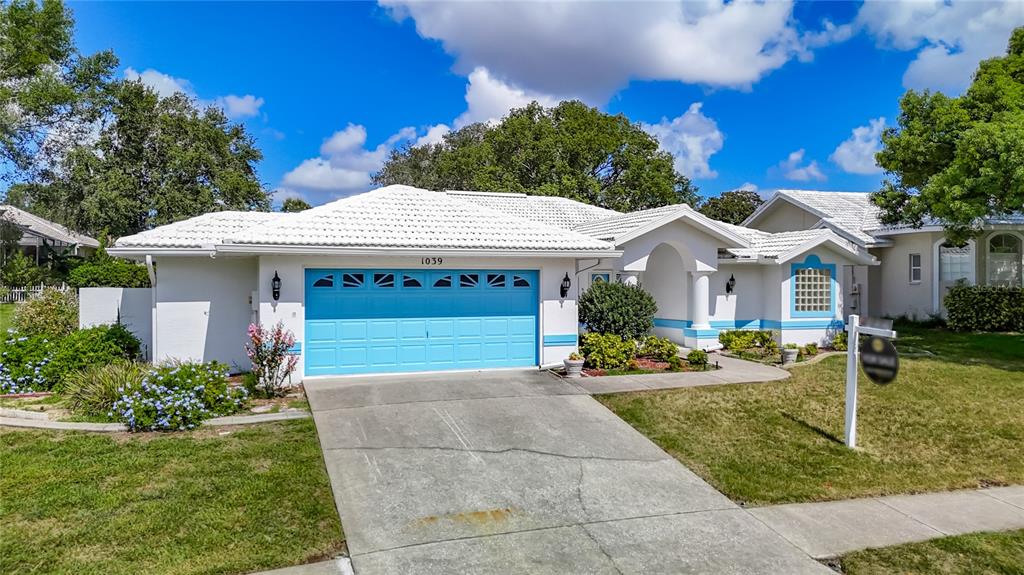 1039 Greenturf Road Spring Hill, FL 34608 - Photo 4 of 52 a front view of a house with a yard garage and outdoor seating