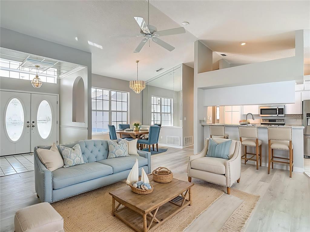 1039 Greenturf Road Spring Hill, FL 34608 - Photo 5 of 60 a living room with furniture kitchen view and a chandelier