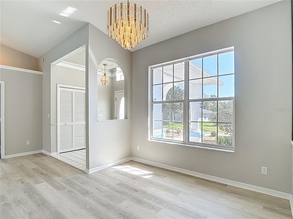 1039 Greenturf Road Spring Hill, FL 34608 - Photo 7 of 60 an empty room with wooden floor and windows
