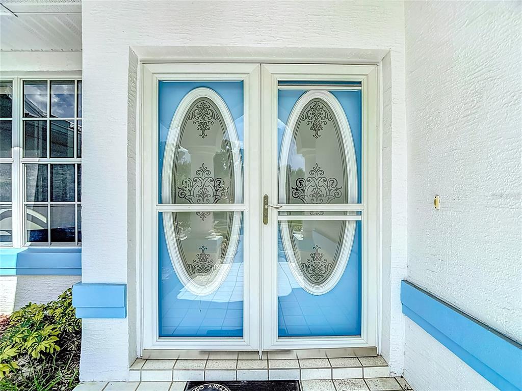 1039 Greenturf Road Spring Hill, FL 34608 - Photo 8 of 52 a front view of a house with large windows and a potted plant