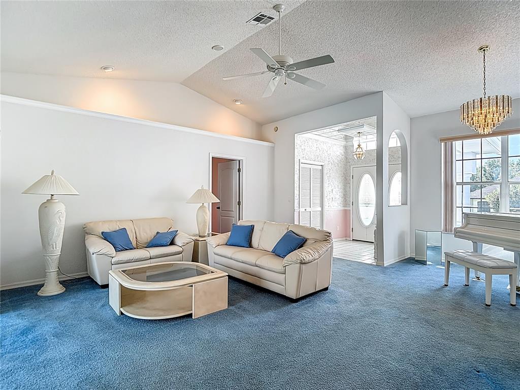 1039 Greenturf Road Spring Hill, FL 34608 - Photo 10 of 52 a living room with furniture and a chandelier