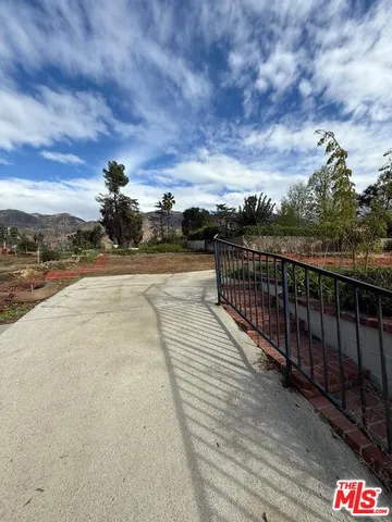 a view of a pathway with a wrought fence