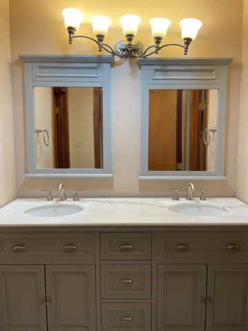 a bathroom with a double vanity sink and a mirror
