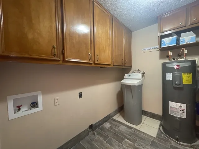 an empty room with a chandelier fan and windows