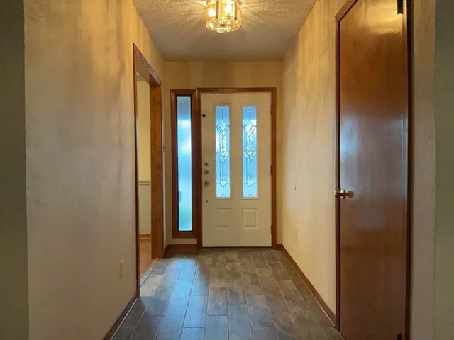 a view of a hallway with wooden floor and chandelier