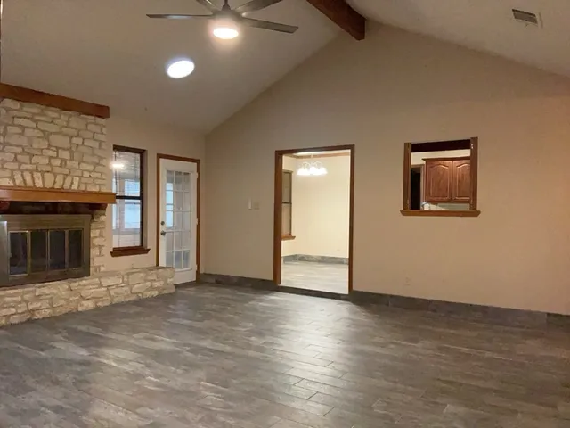 an empty room with wooden floor and a fireplace