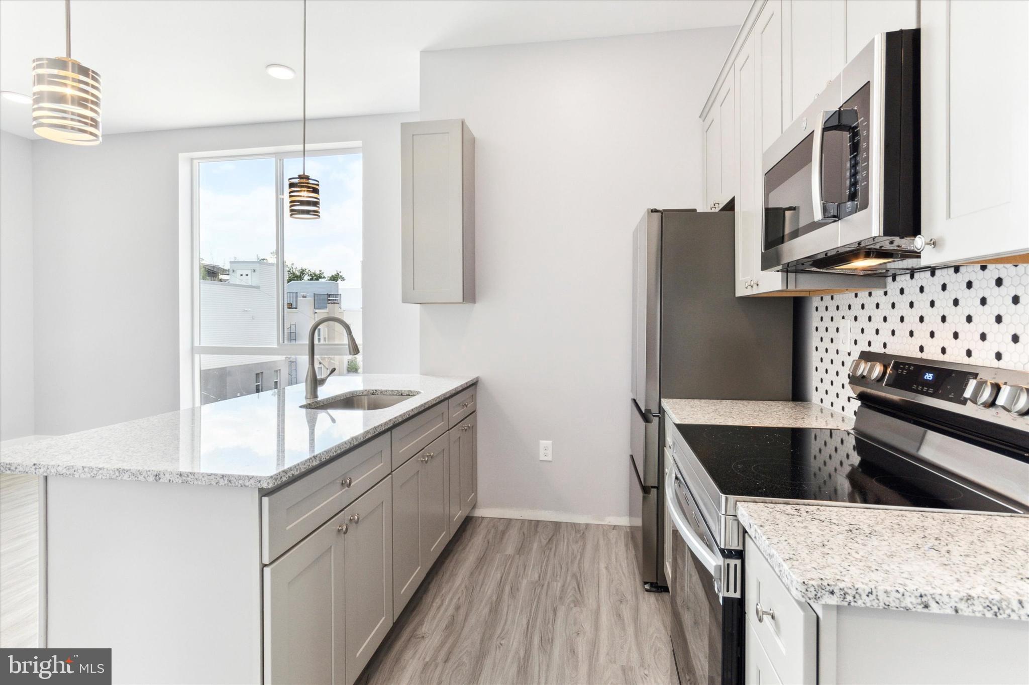 650 South Street, Unit 3 Philadelphia, PA 19147 - Photo 3 of 13 a kitchen with stainless steel appliances granite countertop a sink stove and refrigerator