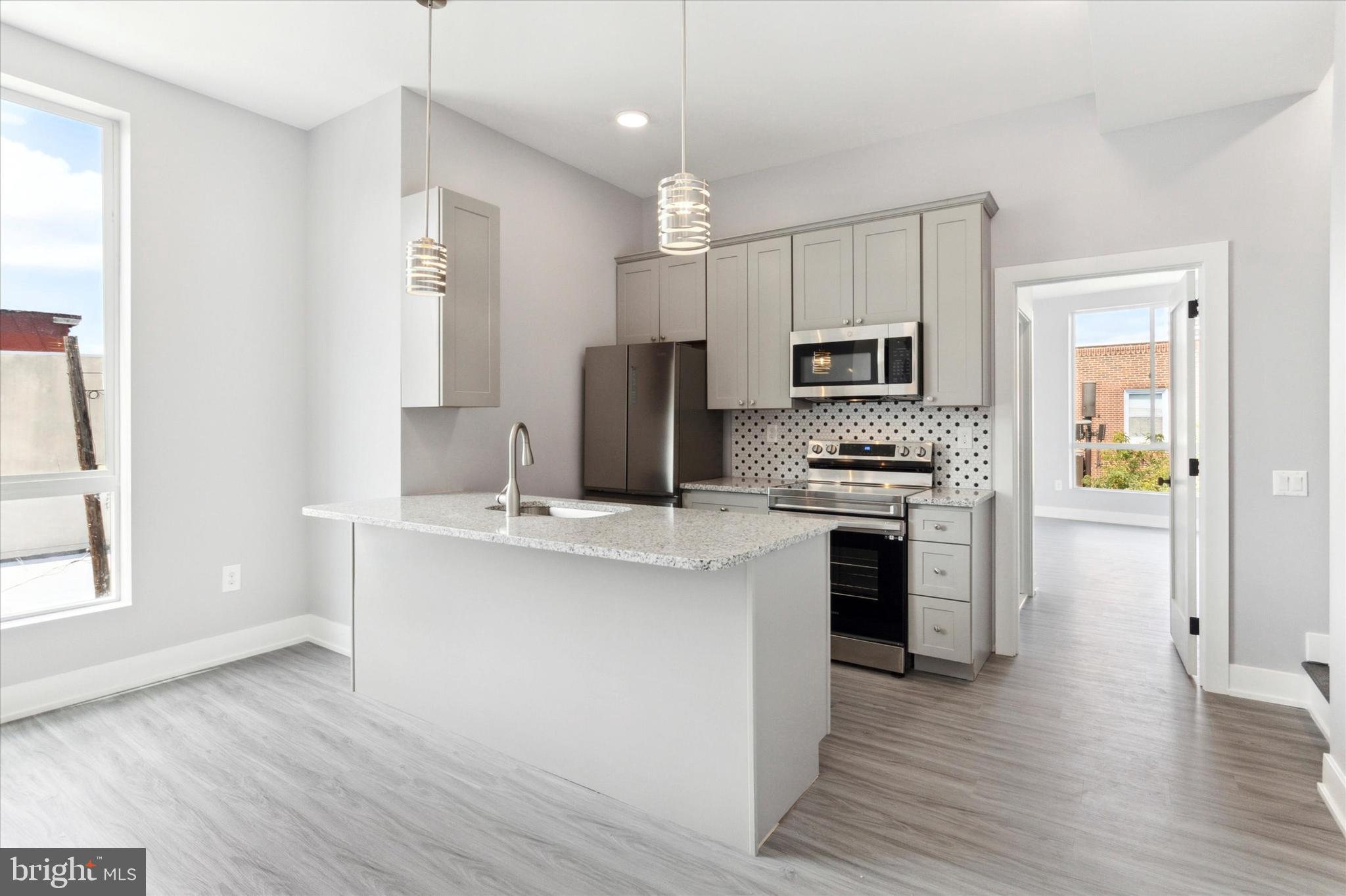 650 South Street, Unit 3 Philadelphia, PA 19147 - Photo 5 of 13 a kitchen with kitchen island white cabinets and stainless steel appliances