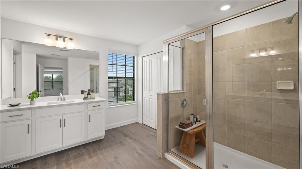 21090 Verawood Loop Estero, FL 33928 - Photo 11 of 17 a bathroom with a double vanity sink a large mirror and a shower