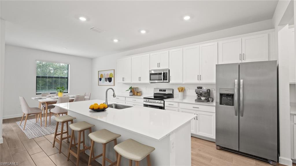 21090 Verawood Loop Estero, FL 33928 - Photo 2 of 17 a kitchen with a refrigerator a stove a dining table and chairs