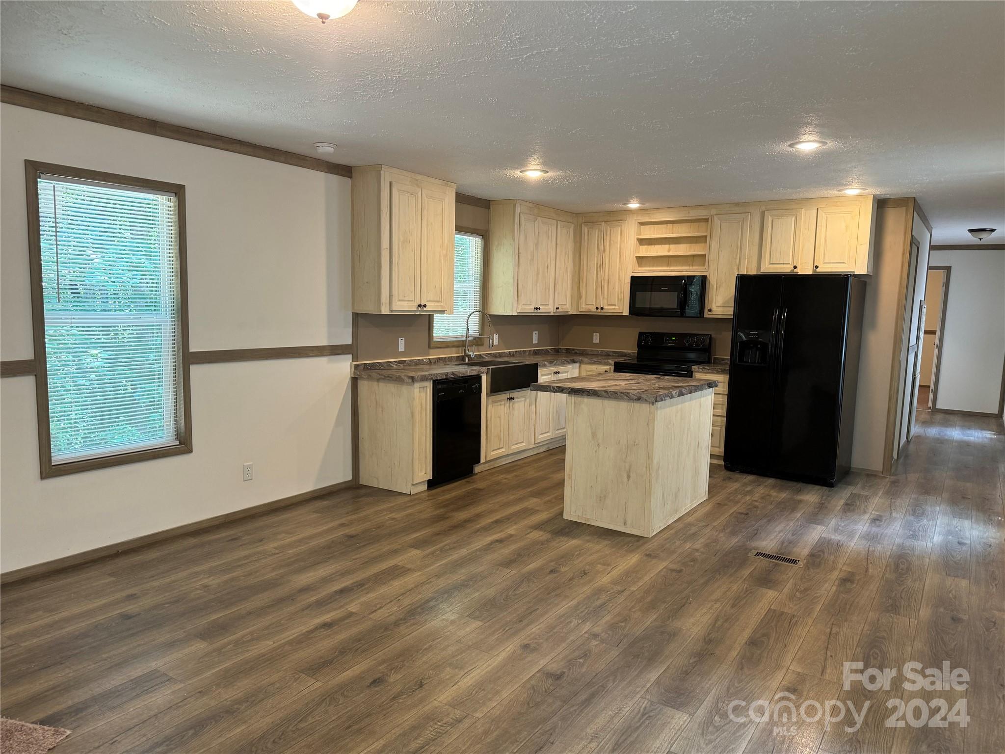 4730 Crystal Creek Road Morganton, NC 28655 - Photo 9 of 17 a kitchen with stainless steel appliances granite countertop a stove top oven a refrigerator a sink and dishwasher with wooden floor
