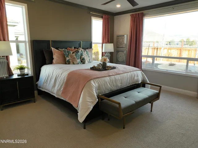 a bedroom with a bed and large windows