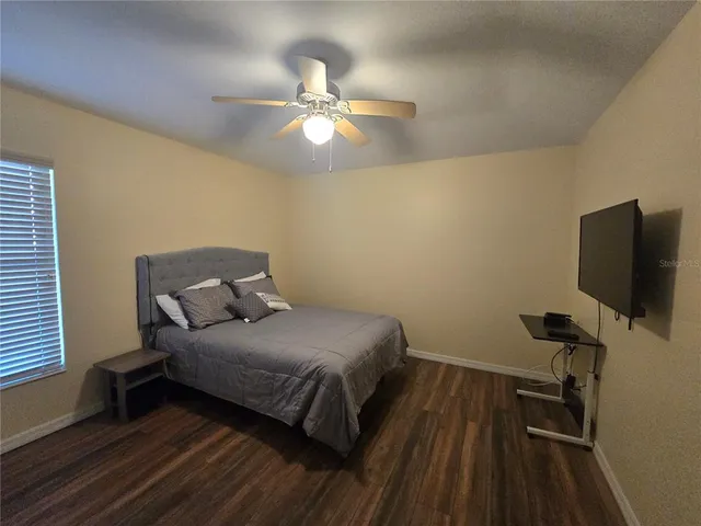 a bedroom with a bed and a flat tv screen on the dresser
