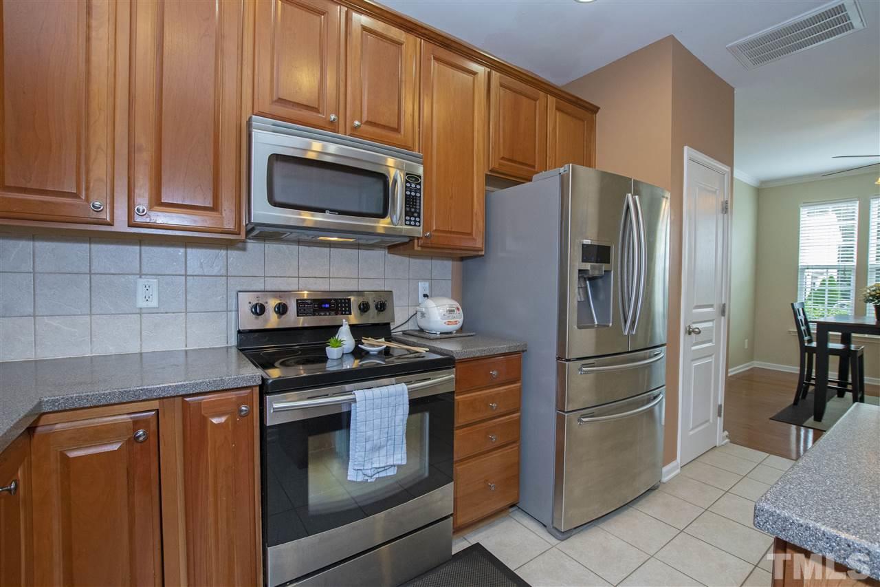 7879 Spungold Street Raleigh, NC 27617 - Photo 12 of 25 a kitchen with stainless steel appliances granite countertop a refrigerator stove and microwave