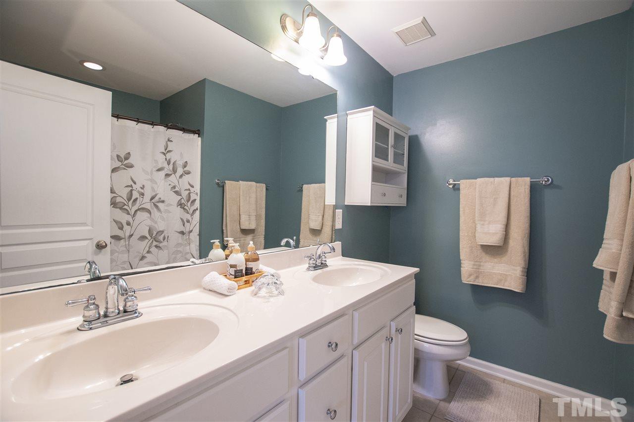 7879 Spungold Street Raleigh, NC 27617 - Photo 15 of 25 a bathroom with a double vanity sink toilet and mirror