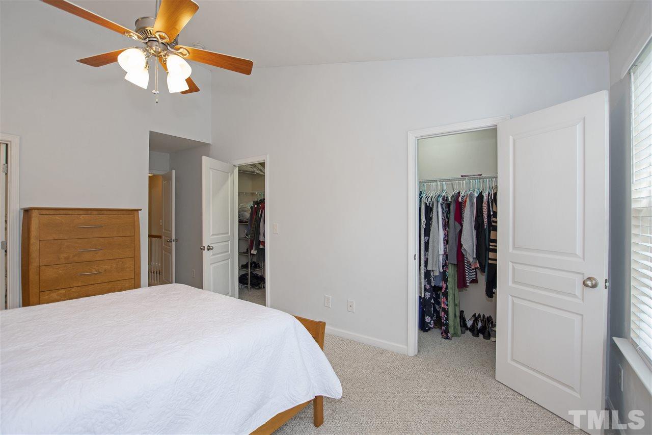 7879 Spungold Street Raleigh, NC 27617 - Photo 16 of 25 a bedroom with a bed and a ceiling fan