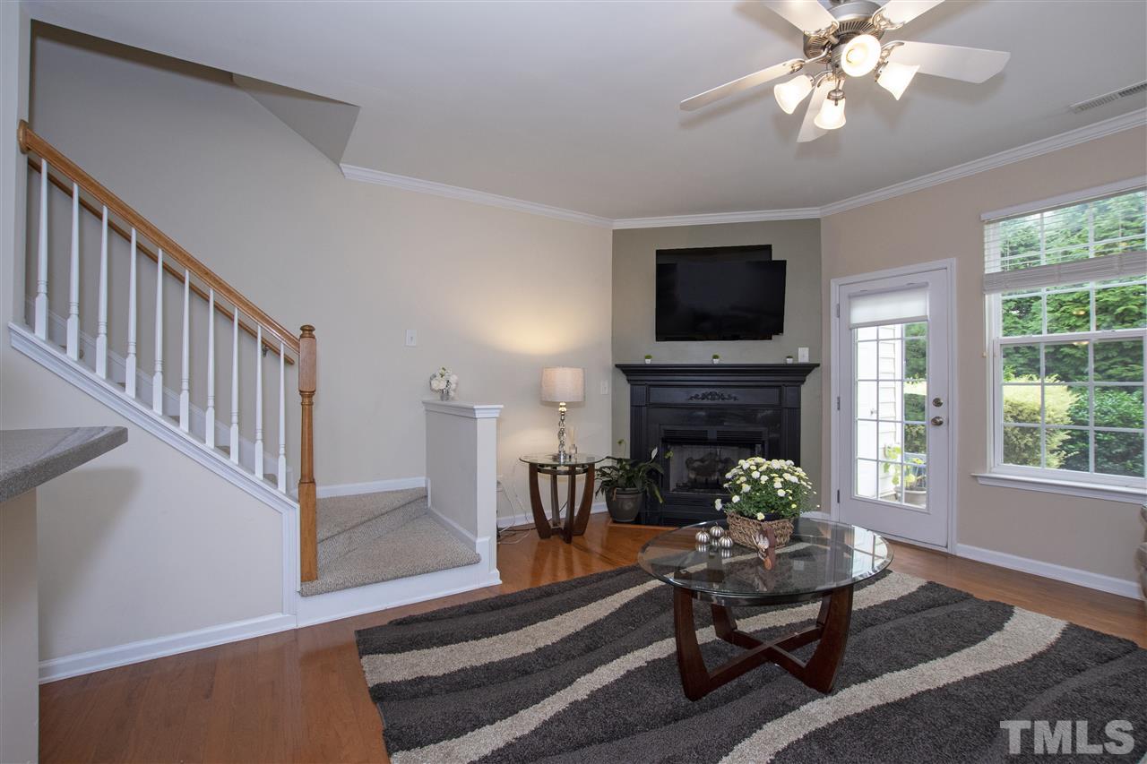 7879 Spungold Street Raleigh, NC 27617 - Photo 4 of 25 a living room with furniture a fireplace and a flat screen tv