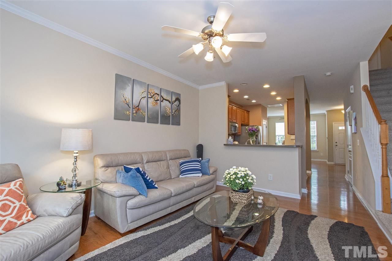 7879 Spungold Street Raleigh, NC 27617 - Photo 5 of 25 a living room with furniture and a chandelier