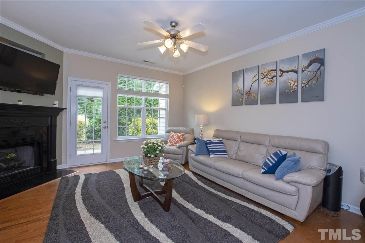 7879 Spungold Street Raleigh, NC 27617 - Photo 6 of 25 a living room with furniture fireplace and flat screen tv