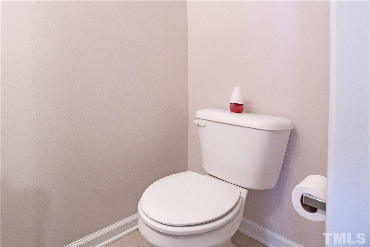 7879 Spungold Street Raleigh, NC 27617 - Photo 9 of 25 a white toilet sitting next to a white sink and vanity