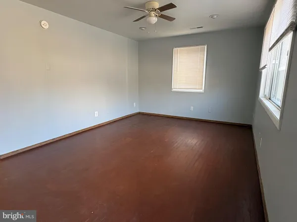 an empty room with a window and a ceiling fan